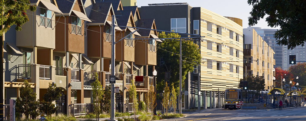 Photograph showing the front façades of the three-story townhomes of La Valentina North and the four-story apartment buildings of La Valentina Station.