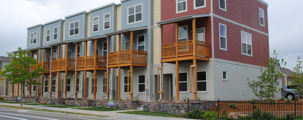 Photograph showing six 3-story townhomes. 