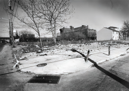 A vacant and abandoned lot littered with refuse.