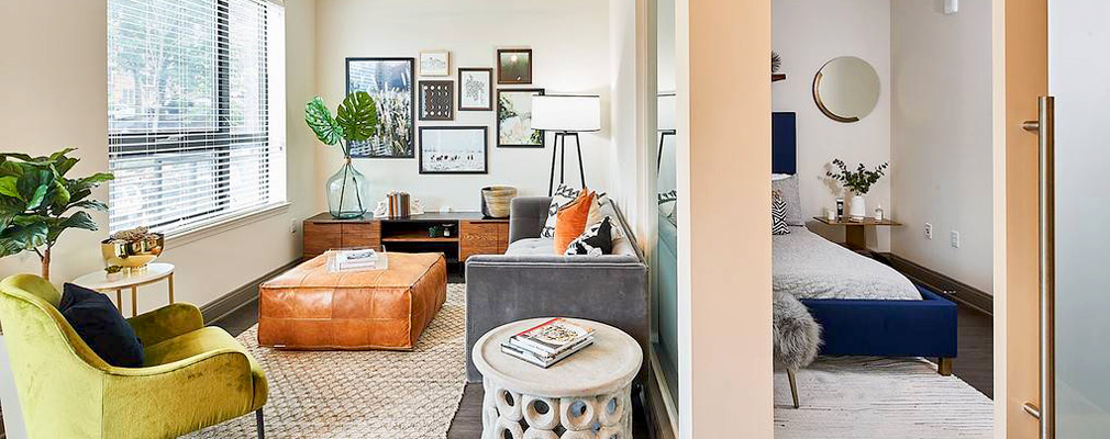 Photograph of the interior of an apartment showing a living area and an adjacent bedroom. Photograph of the interior of an apartment showing a living area and an adjacent bedroom.