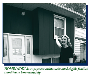A proud homeowner standing in front of her house.