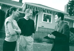 A picture of a homebuying couple talking to a real estate agent.