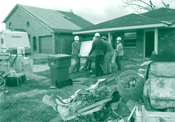 A picture of students removing the belongings from a hurricane-damaged home in the Gulf Coast.