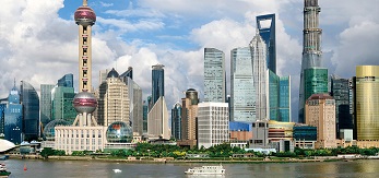 Photograph of the skyline of the Pudong district of Shanghai, China. The Huangpu River is visible in the foreground.