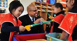 Assistant Deputy Secretary Jim Shelton shown with a group of children after announcing the $28 million Promise Neighborhoods grant for the Northside Achievement Zone at Elizabeth Hall International Elementary School in Minneapolis on Dec. 19.