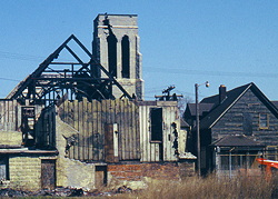 An image of a burned-out church as seen across vacant lots once occupied by dwellings.
