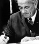 Lyndon B. Johnson signing paper.