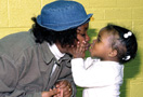 Child holding woman’s cheeks and kissing her.