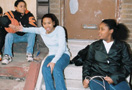 Three youth sitting on stoop.