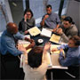 Group of six people working at table.