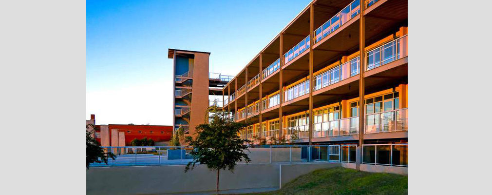 Photograph of the exterior of a three-story residential building. 