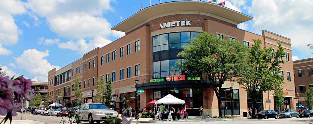 Photograph of three-story masonry buildings lining two streets at an intersection.