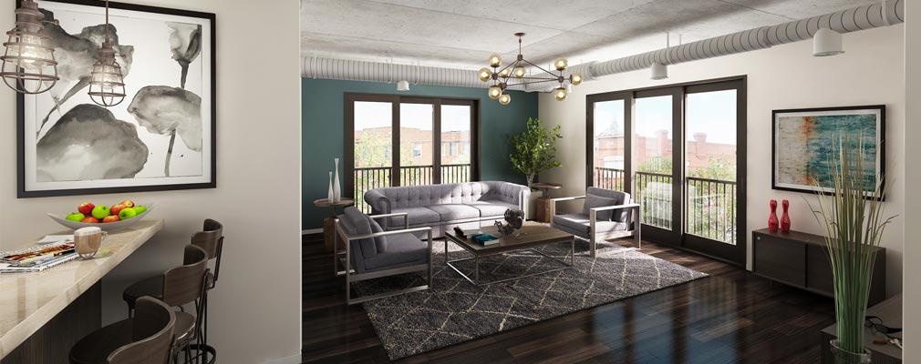 Photograph of the living area of an apartment with large windows providing sunlight and views of the downtown.