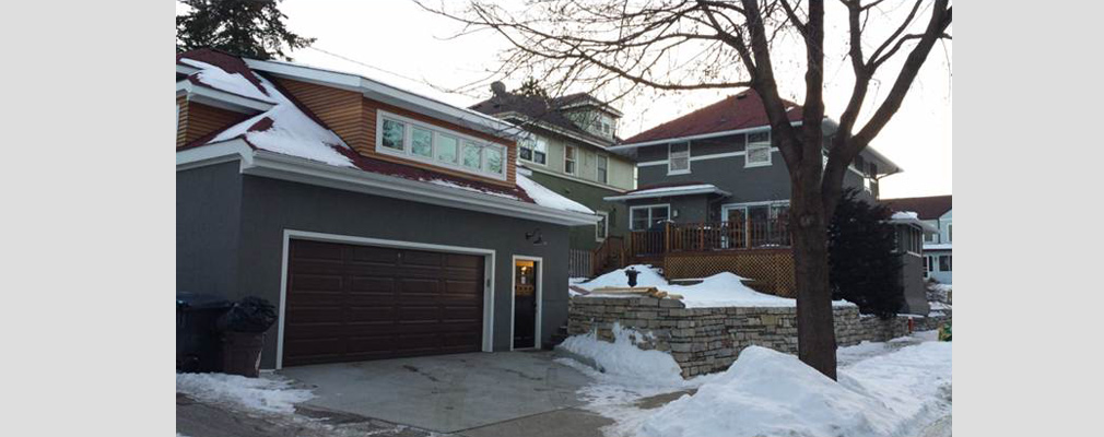 A view of three residential buildings as seen from the street.