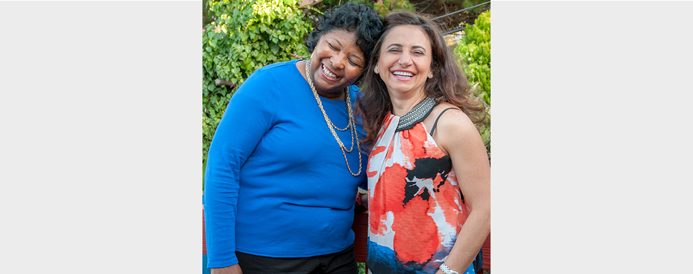 Two women standing next to each other pose for the photo.