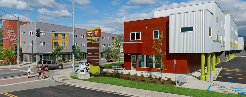 Photograph of an intersection in Mountain View showing two new three-story mixed-use buildings that have been developed along the commercial corridor.