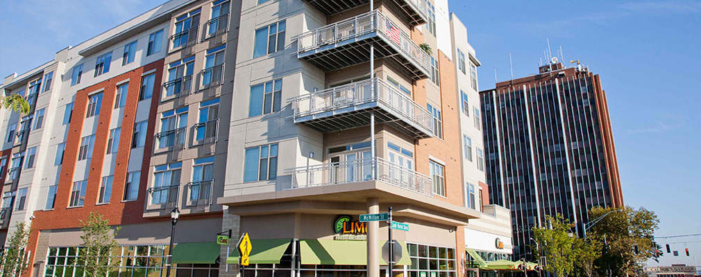 Photograph of the two street façades of a corner building, with commercial uses on the first floor and residential uses on the four upper floors.