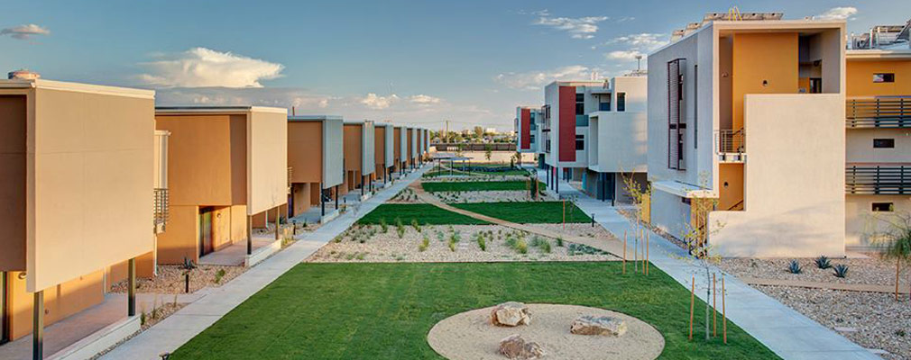 Photograph of the Paisano Green Community showing the landscaped courtyard between the townhouse and apartment buildings. 