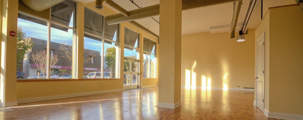 Photograph of the interior of large room with plate glass windows running across the exterior wall. 