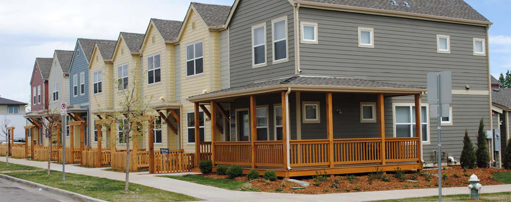 Photograph showing eight 2-story townhomes with shallow building setbacks from the street. 