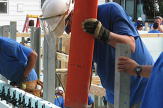 A worker filling an ICF wall with concrete.