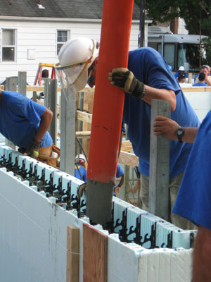 A worker filling an ICF wall with concrete.
