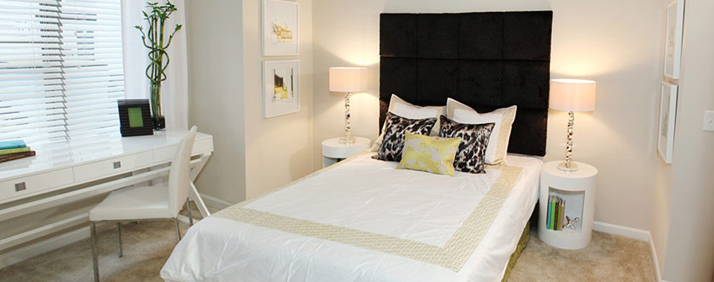 Photograph of a bedroom with a bed and built-in desk.