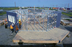 The work crew fitting siding on the octagon house