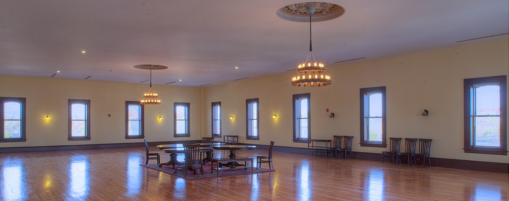 Photograph of a large, open interior space, with four and five widely spaced window bays in the two walls in the background.  