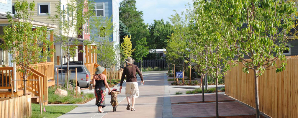 Photograph showing two adults and a small child walking in the woonerf.