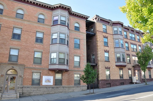 Photograph of the front façade of a four-story brick residential building.