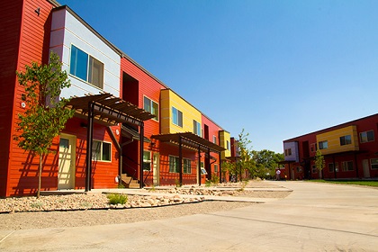 Photograph taken from near sidewalk level showing the front facades of two of the nine two-story residential buildings in Cinema Court.