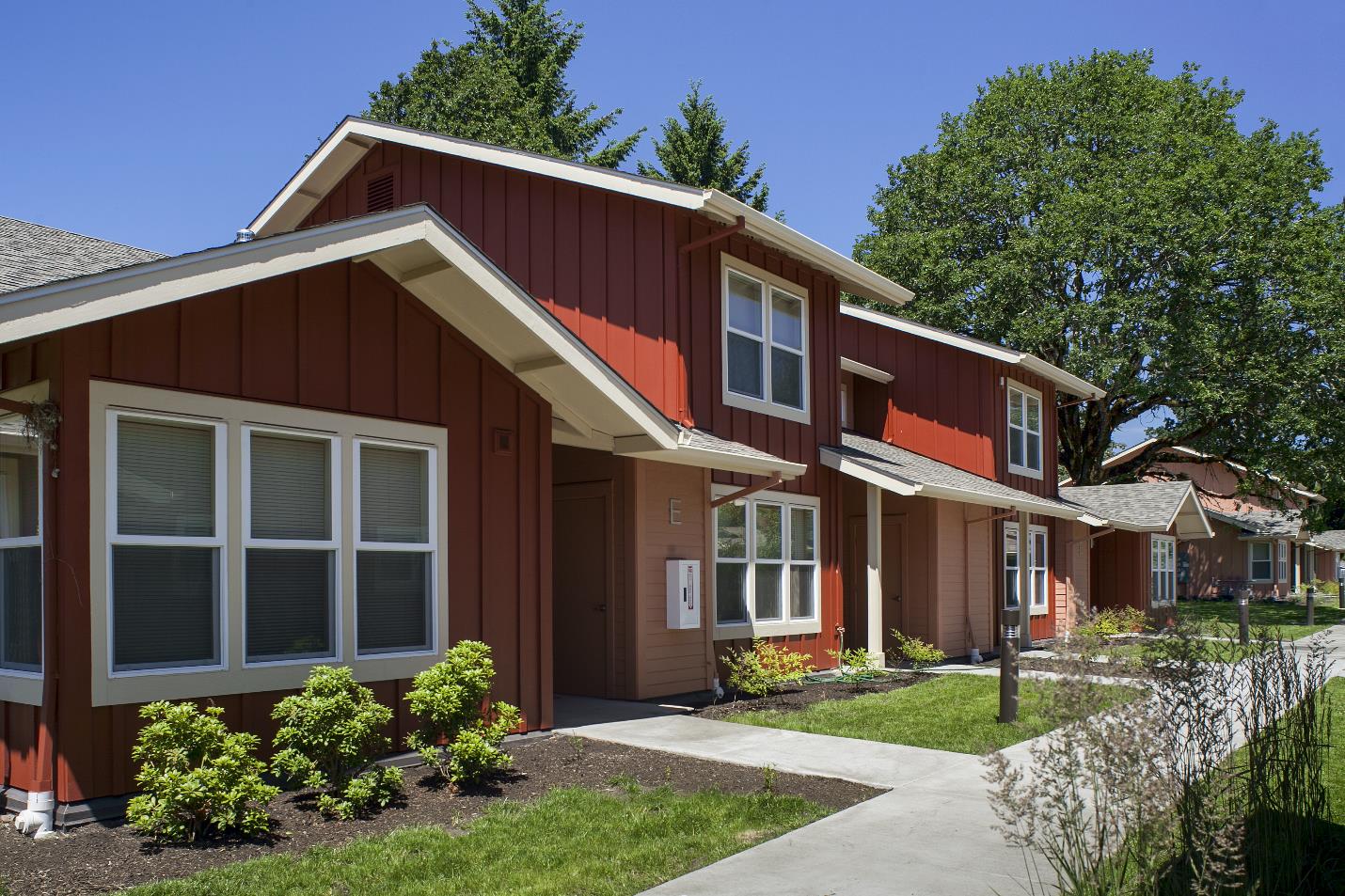  Exterior image of two-story, townhouse-style apartments with exterior mudrooms.