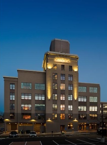 Image of the Buzza Lofts lit up at night.