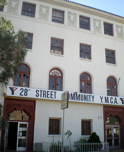 Photograph of the front façade of the 28th Street YMCA in Los Angeles. The building is shown to have large windows and landscaping along the front wall.