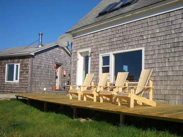 Image of a Nova Scotia home with a shared porch where a room has been removed. The main house is  in the foreground; the cottage is on the left.