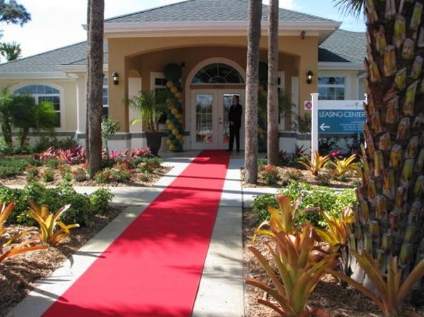 Photograph taken from the entrance walkway showing the main entrance to the new clubhouse, along with landscaping, at Emerald Villas.