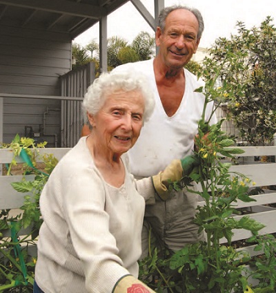 A Concierge Club member receives assistance with her gardening from a volunteer.