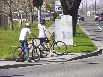 Two young boys riding bikes in their neighborhood.