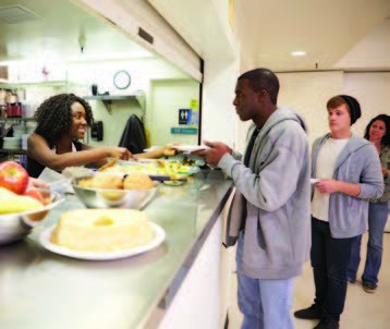 Homeless youth being served by food kitchen workers.