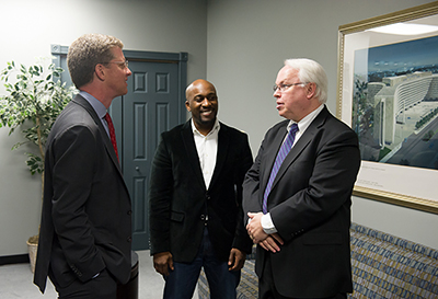 Photo shows HUD Secretary Shaun Donovan chatting with Steve Brady and Fred Freiberg.