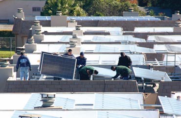 Image of Young adults from the YouthBuild program equip multifamily housing buildings with solar panels while learning to install the new technology.