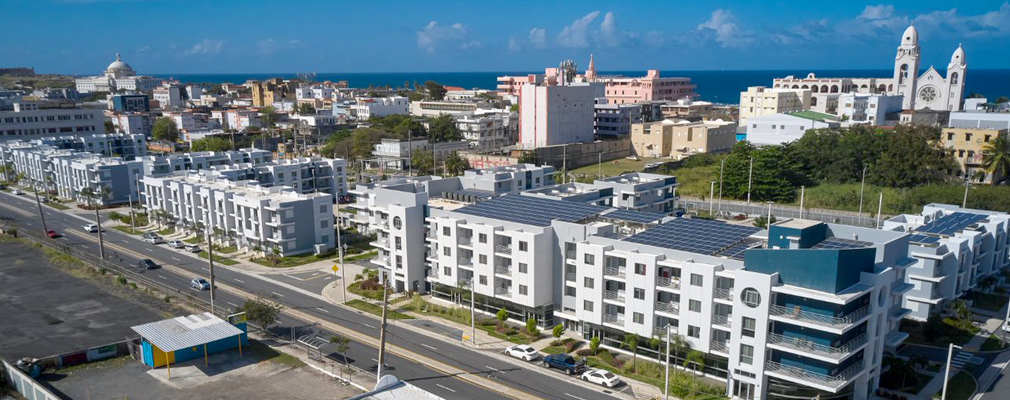 Low-angel aerial photograph of several 4-story residential buildings.