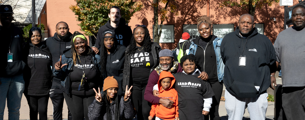 A posed group photograph of smiling people wearing Lead Safe Resource Center t-shirts.