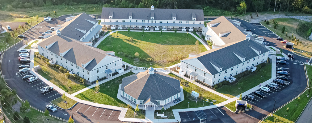 Aerial view of low-rise apartment buildings arranged around a pentagonal courtyard.