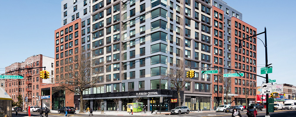 A 14-story, mixed-material building situated at a busy intersection.