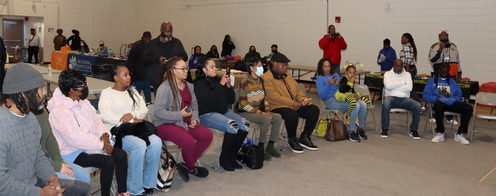 Residents seated in the community room engaging in dialogue.