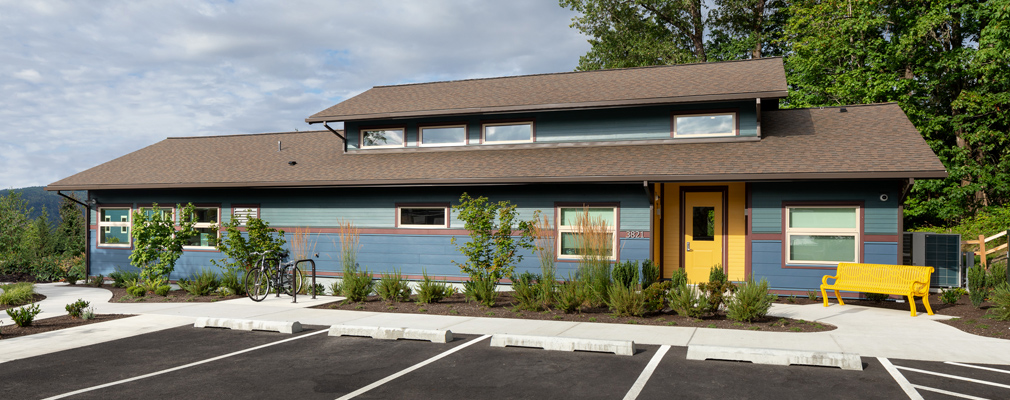 Front façade of a one-story building with parking spaces in the foreground.