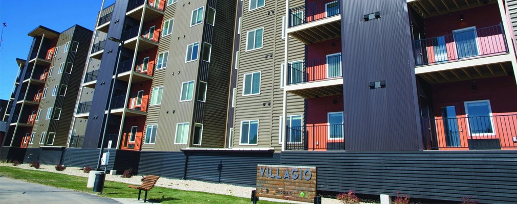A five-story apartment building with a "Villagio" sign in the front at ground level.