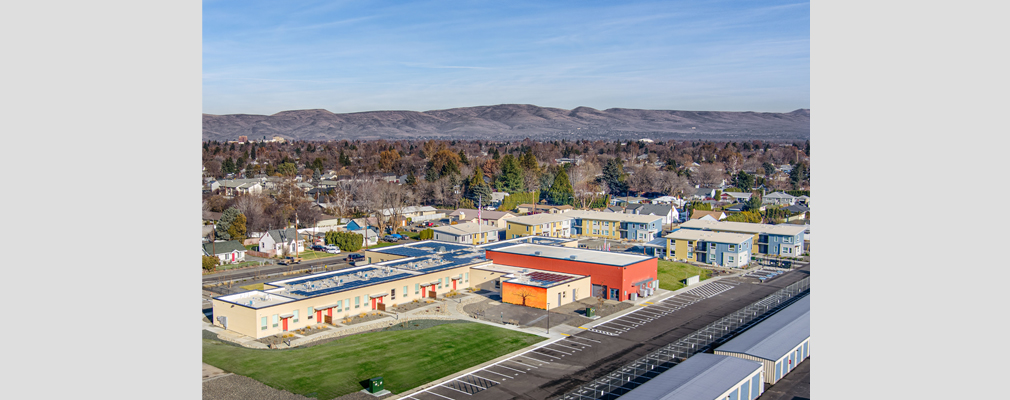 Photograph of the entire Chuck Austin Place development, with buildings in the foreground and mountains in the background.